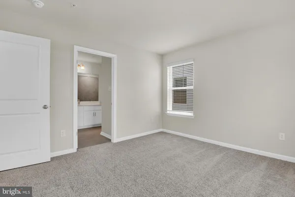 an empty room with a bathroom and a window