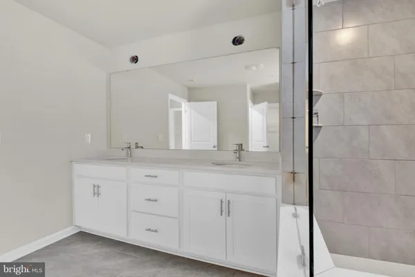 a bathroom with a double vanity sink and mirror