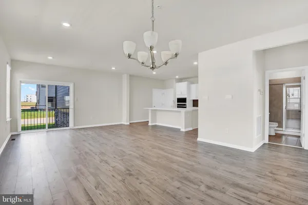 a view of a livingroom with a furniture wooden floor and a kitchen