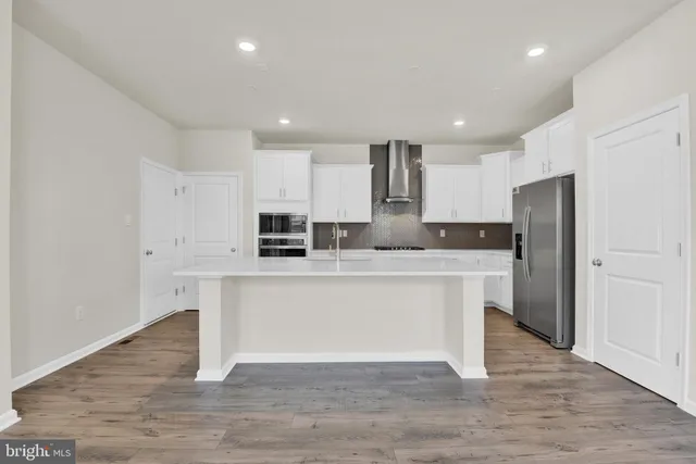 a kitchen with kitchen island white cabinets and stainless steel appliances