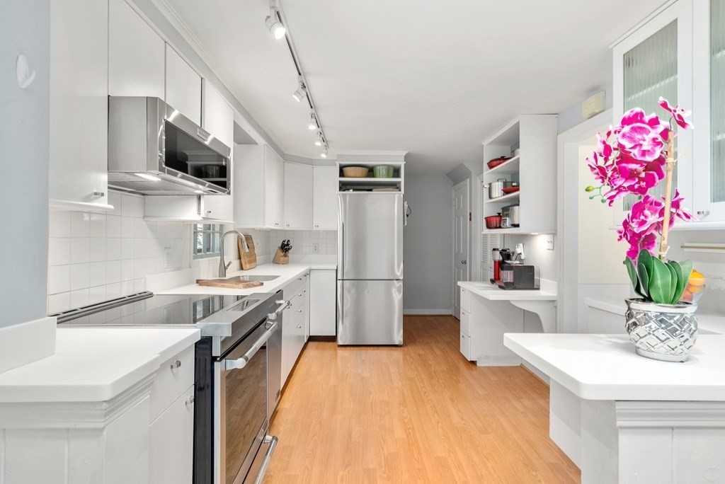 60 Valley Road Milton, MA 02186 - Photo 7 of 28 a kitchen with granite countertop a sink stainless steel appliances and white cabinets