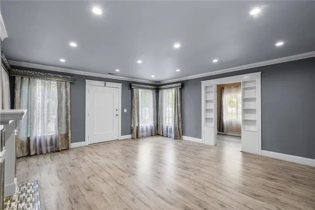 a view of a livingroom with wooden floor and a fireplace