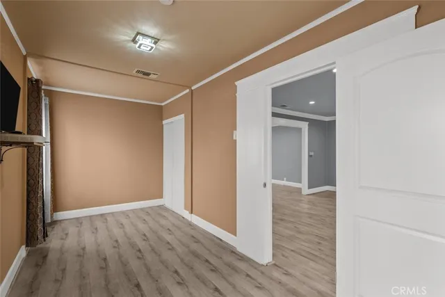 a view of empty room with wooden floor