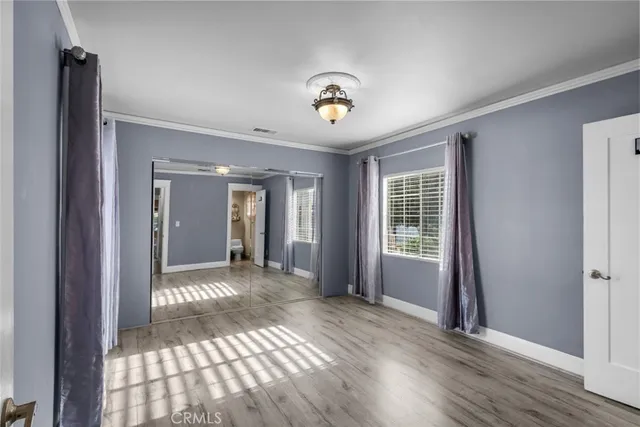a view of a hallway with wooden floor and a livingroom