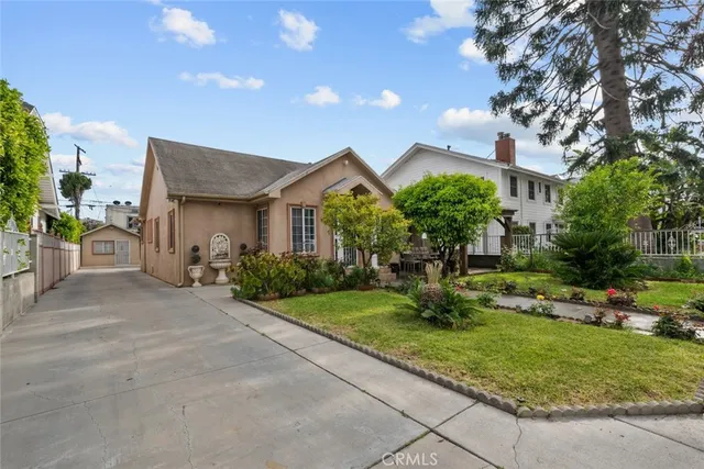 a front view of a house with a yard and trees