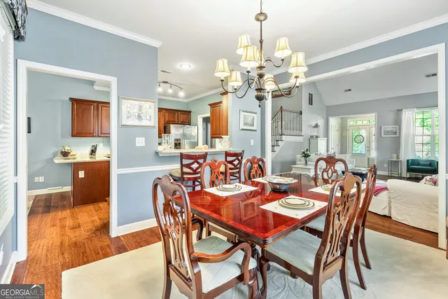 a dining room with furniture large windows and wooden floor