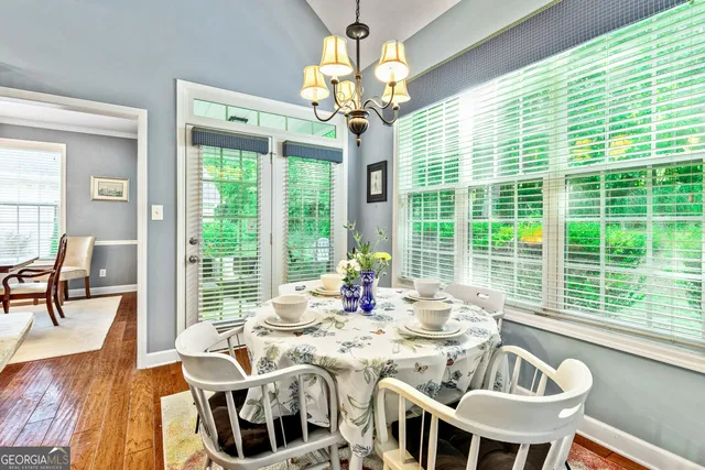 a view of a dining room with furniture a chandelier and wooden floor