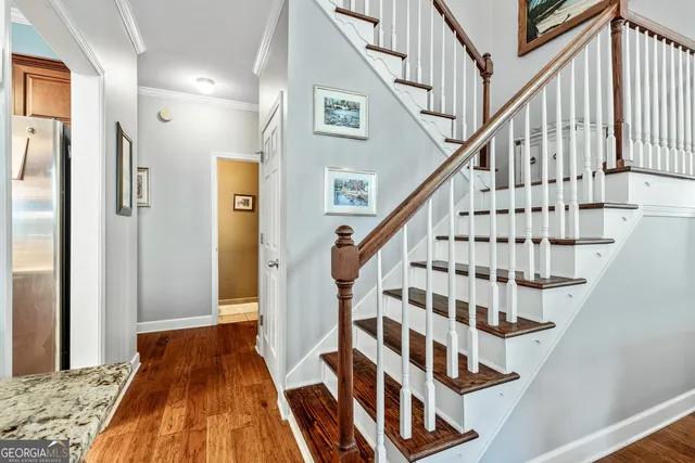 a view of a hallway with wooden floor and a dining room