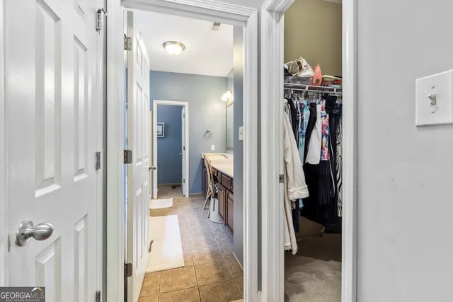 a view of walk in closet with clothes and shoes