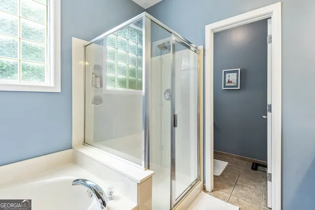 a bathroom with a tub a sink and a window