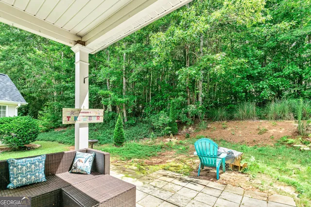 a view of a chair and table in backyard of the house