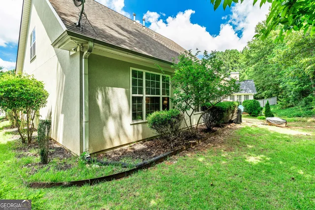 a view of house with garden and tall trees