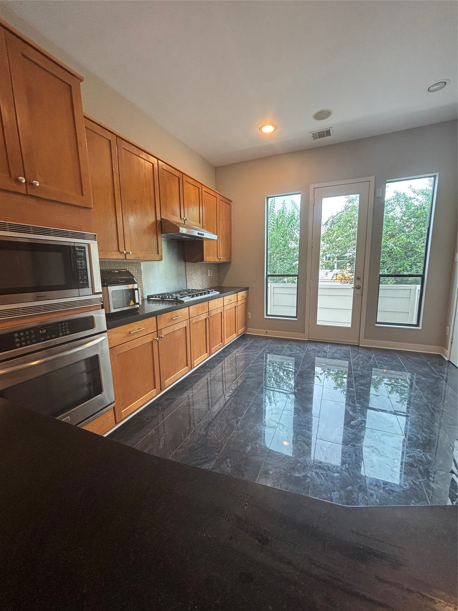 6016 Truro Street Houston, TX 77007 - Photo 9 of 26 Spacious Kitchen with corean counters, gas cooktop, double ovens, extensive storage, and access to a private outdoor balcony