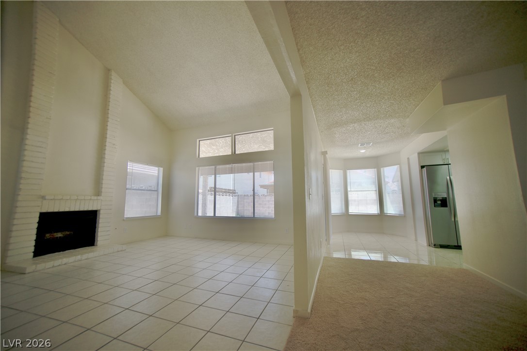 6501 Hartwood Road Las Vegas, NV 89108 - Photo 6 of 32 A welcoming living space features a cozy fireplace and abundant natural light.