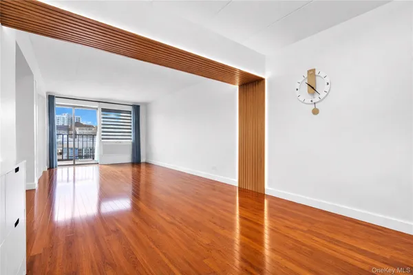 a view of empty room with wooden floor and fan