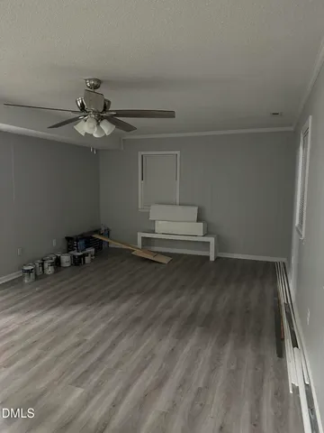 a view of room with wooden floor and ceiling fan