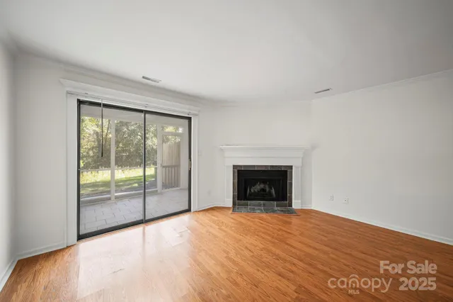 a view of empty room with wooden floor and fireplace