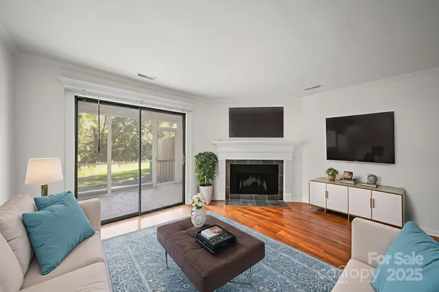 a living room with furniture a flat screen tv and a fireplace
