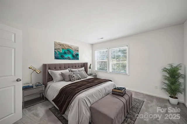 a bedroom with a bed and a potted plant