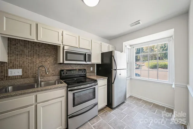 a kitchen with cabinets stainless steel appliances and a sink