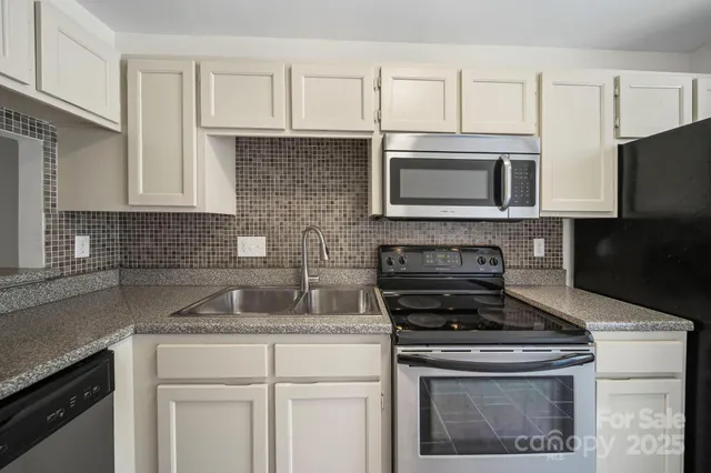 a kitchen with appliances a sink and cabinets