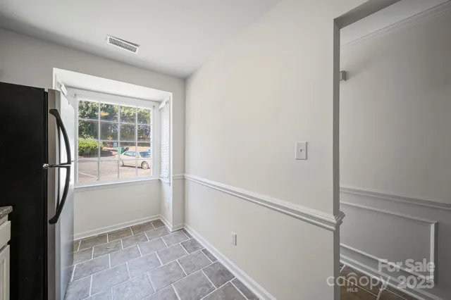 a view of kitchen with furniture and refrigerator