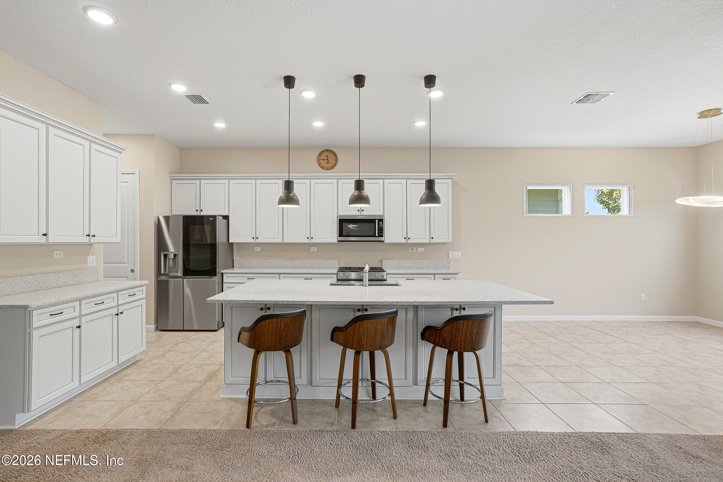 308 Rustic Mill Drive St. Augustine, FL 32092 - Photo 11 of 41 a kitchen with stainless steel appliances kitchen island granite countertop a sink a stove a refrigerator and white cabinets with wooden floor