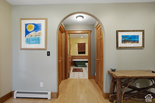 725 Canyon Road Smithfield, UT 84335 - Photo 41 of 100 Wood-finish flooring, arched doorway with wood trim, wood paneled doors, baseboard heating unit, interior light fixture