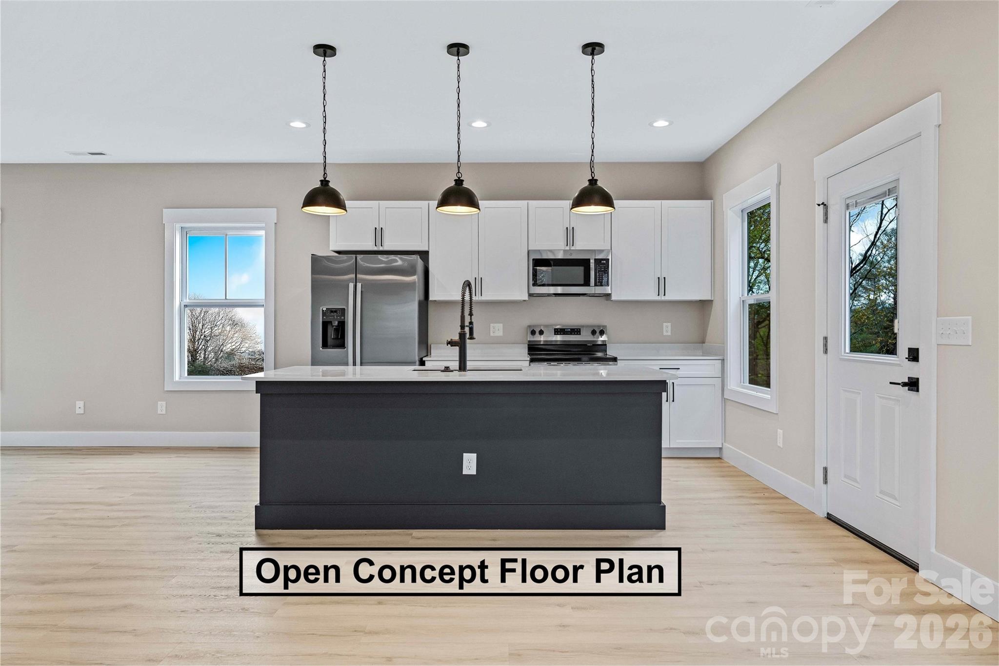 428 Hazel Mill Road Asheville, NC 28806 - Photo 12 of 46 a view of kitchen island with stainless steel appliances granite countertop refrigerator oven and a wooden floor
