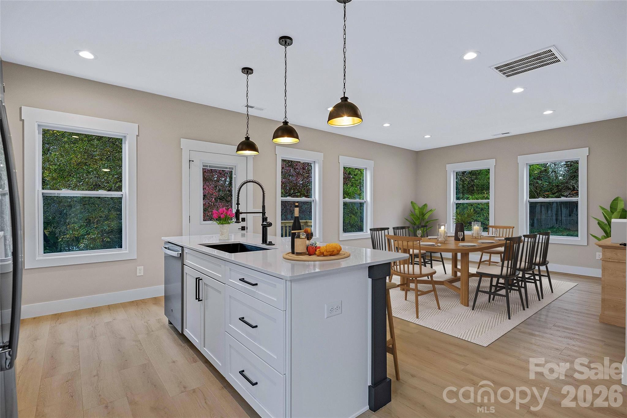 428 Hazel Mill Road Asheville, NC 28806 - Photo 17 of 46 a view of a dining room and livingroom with furniture wooden floor a chandelier