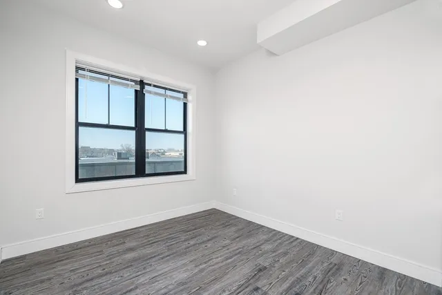 a view of an empty room with wooden floor