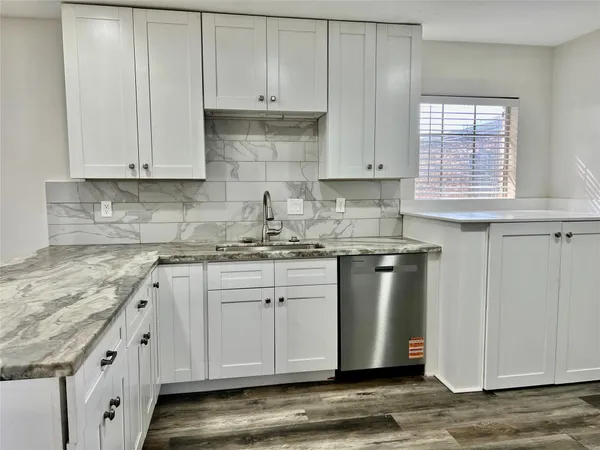 a kitchen with granite countertop white cabinets and white appliances