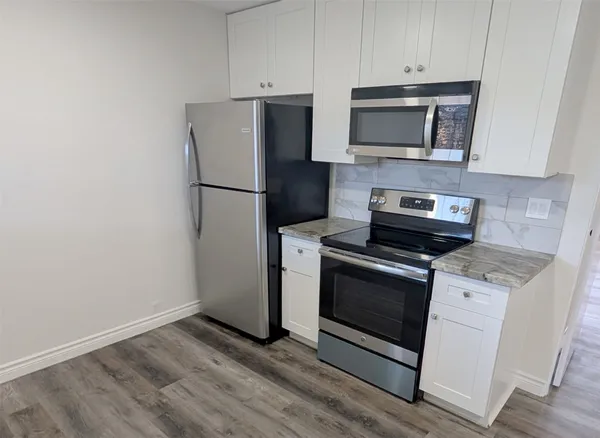 a kitchen with a refrigerator stove and microwave