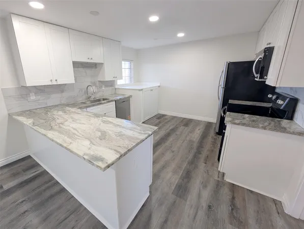 a kitchen with sink cabinets and wooden floor