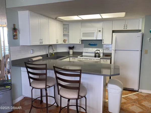 a kitchen with stainless steel appliances granite countertop a sink refrigerator and cabinets