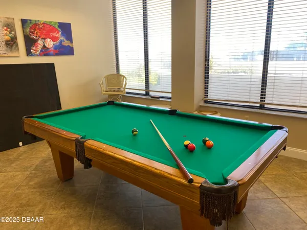 a room with pool table and windows