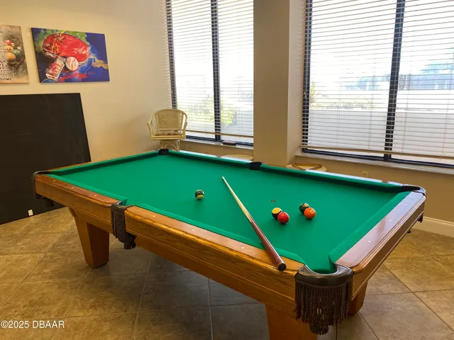 a room with pool table and windows