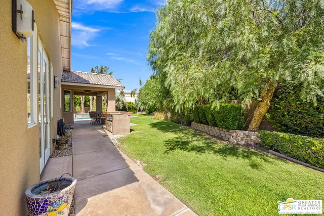 a view of a patio with couches plants and large tree
