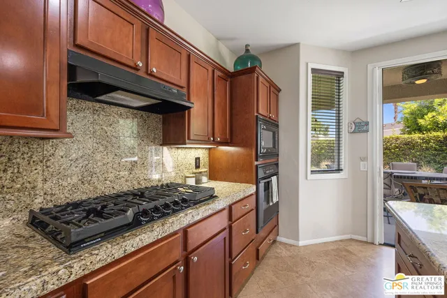 a kitchen with granite countertop a sink and a white cabinets