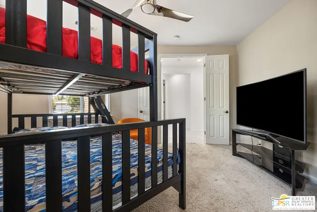 a spacious bedroom with a bed and ceiling fan