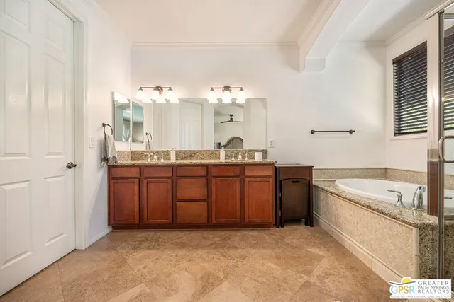 a spacious bathroom with a granite countertop sink a mirror and a bathtub