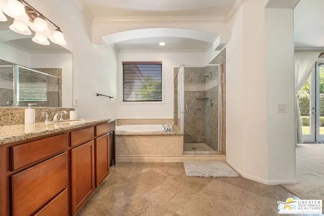 a bathroom with a tub a double vanity sink and shower