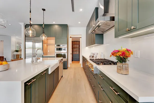 a large kitchen with stainless steel appliances lots of counter space and a sink