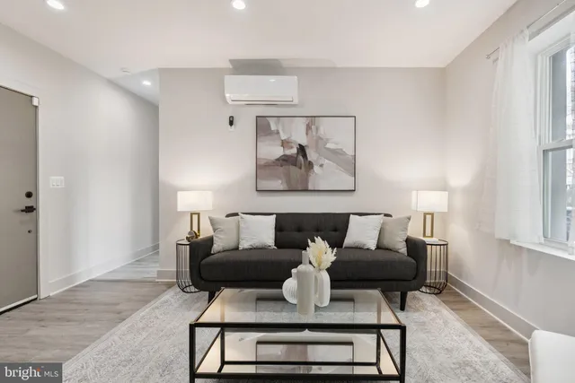 a living room with furniture and a painting on the wall