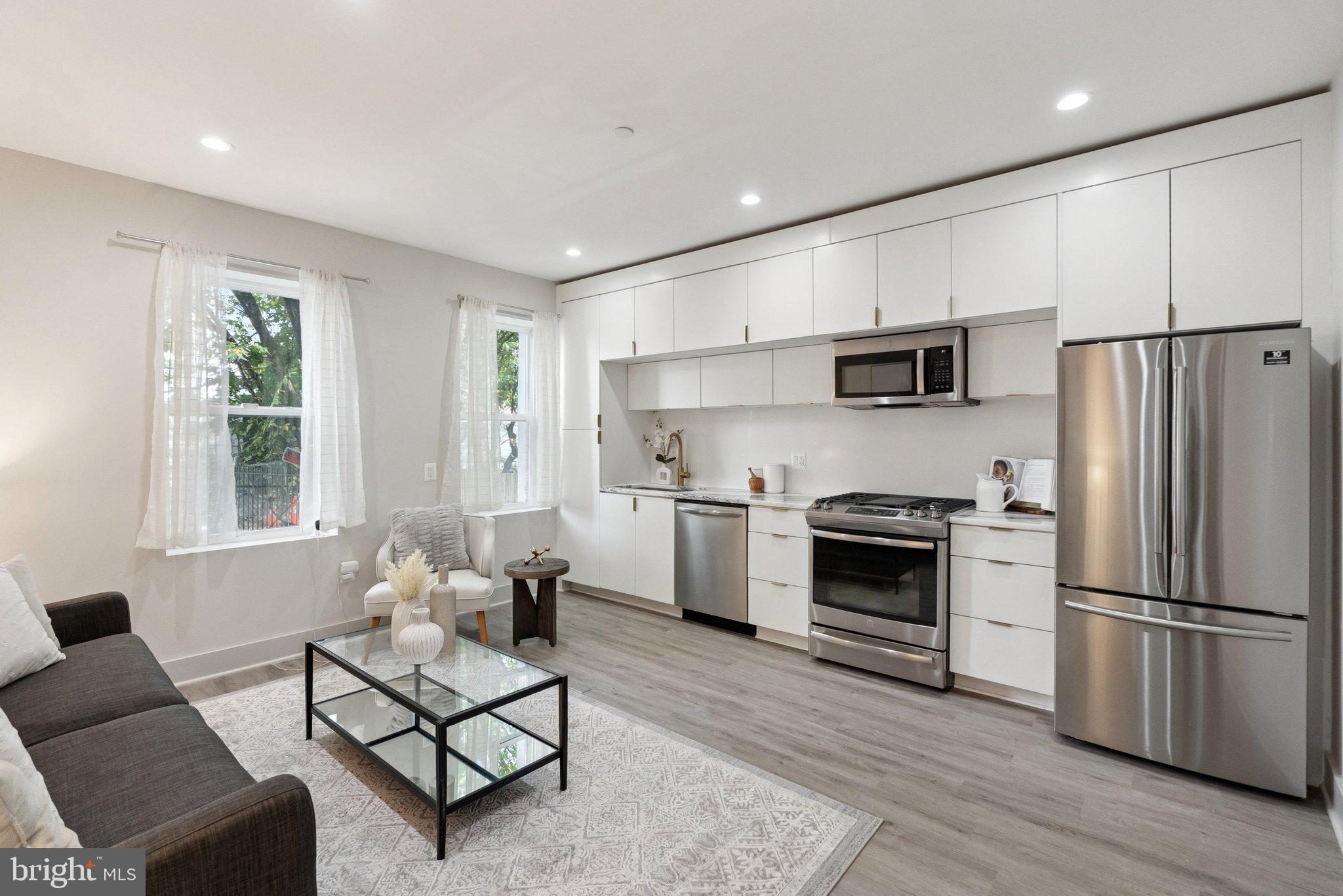 839 Kennedy Street Northwest, Unit 105 Washington, DC 20011 - Photo 3 of 21 a kitchen with cabinets stainless steel appliances a sink and a window