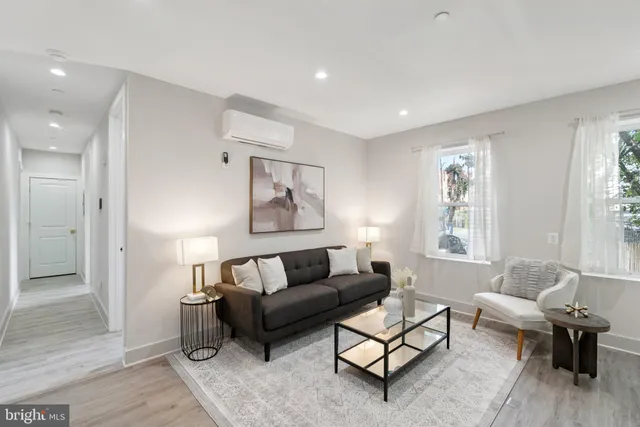 a living room with furniture and a potted plant next to a window