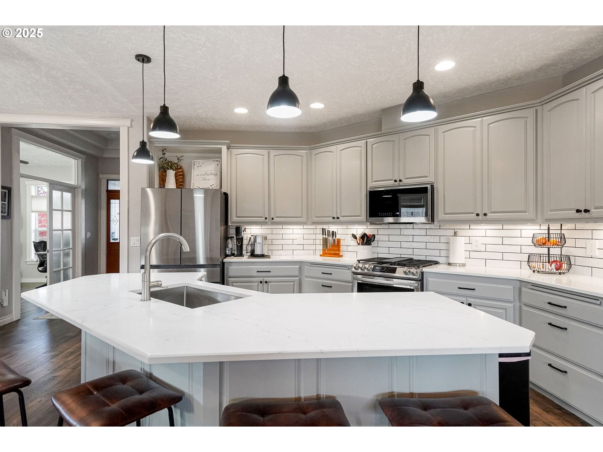 3208 54th Avenue Northeast Albany, OR 97321 - Photo 26 of 43 a kitchen with stainless steel appliances kitchen island granite countertop a sink dishwasher a stove a microwave oven a refrigerator with white cabinets and wooden floor