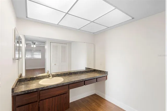 a bathroom with a granite countertop sink and a mirror