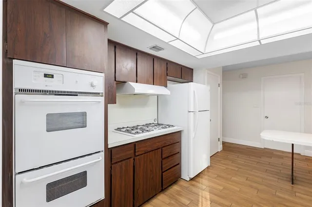 a kitchen with cabinets and wooden floor