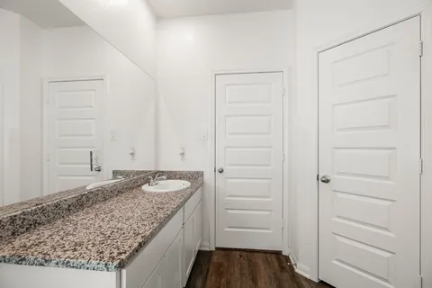 a bathroom with a granite countertop sink and a mirror